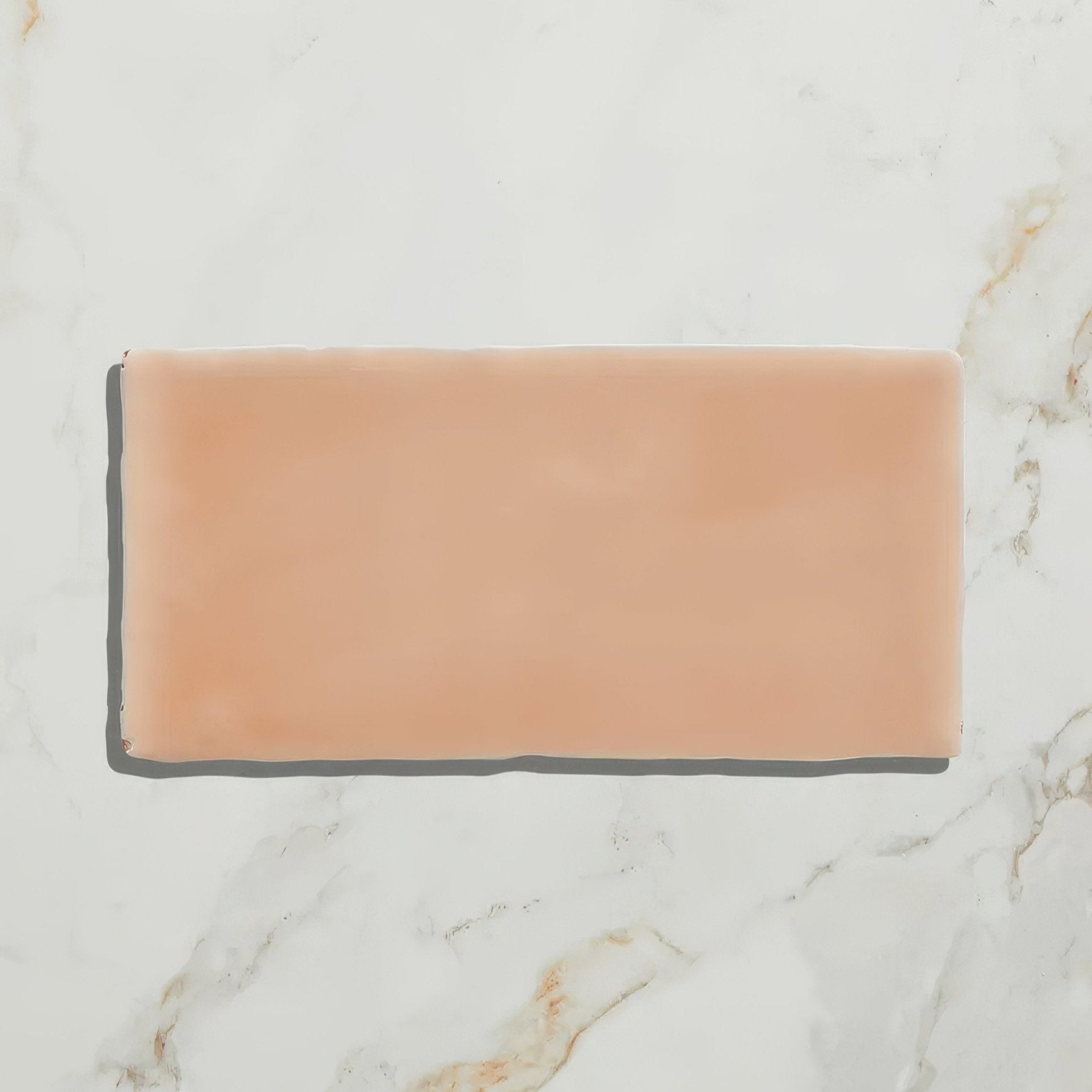 A rectangular peach-colored ceramic tile with a smooth matte finish from the seaton ceramic shrimp collection