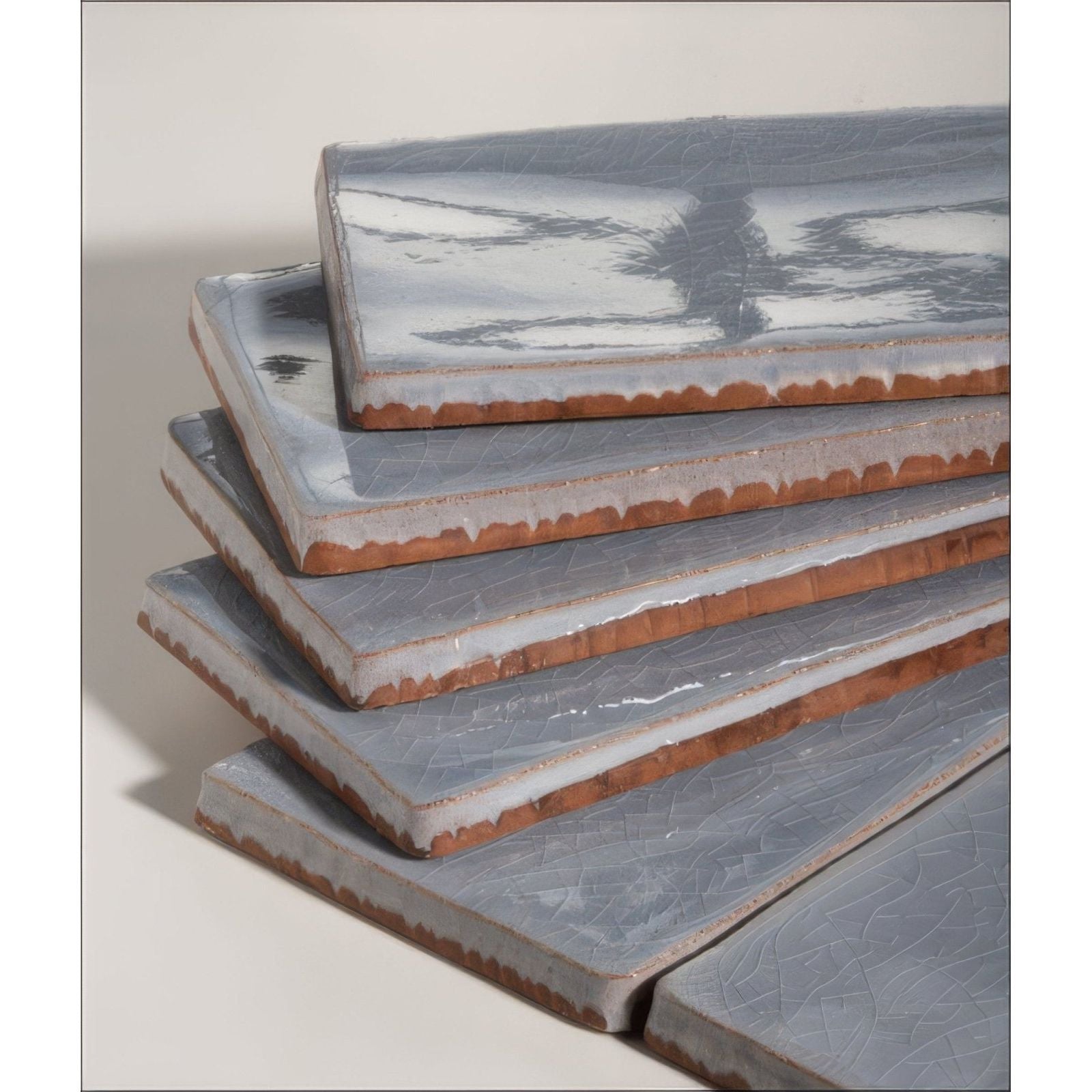 Stack of gray seaton ceramic sky tiles with crackled glaze and exposed terracotta edges