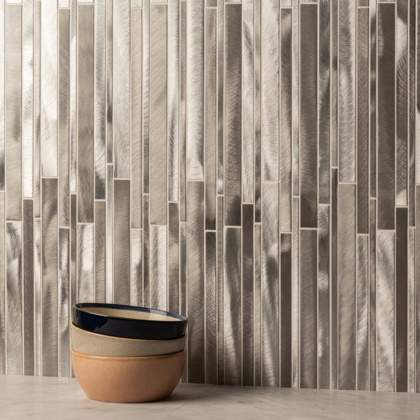 Shard Metal Mosaic silver metallic mosaic with a stack of three ceramic bowls