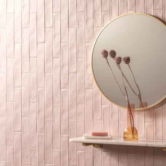 A round sherbet pink brick 5x25cm tile with a thin gold frame shown as a mirror accessory