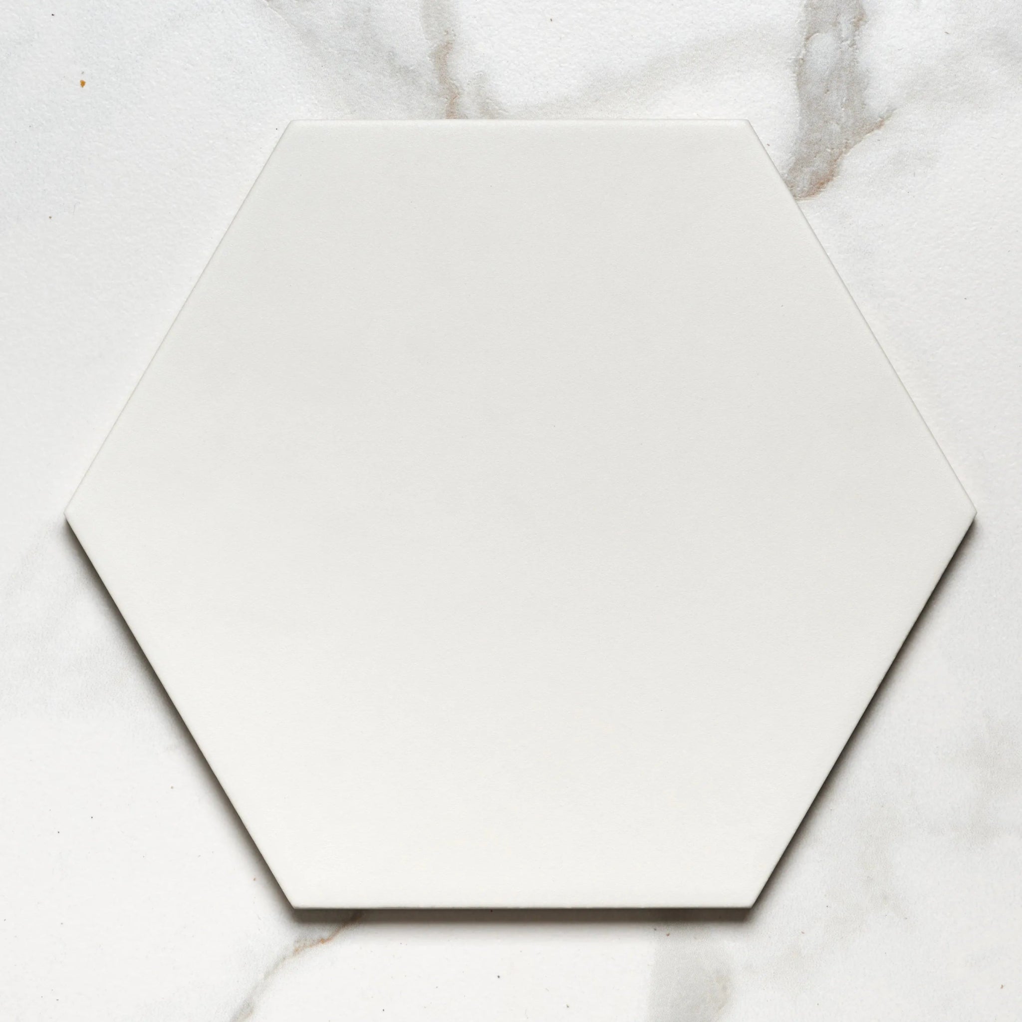 A sleek matte white hexagonal ceramic tile with clean edges from signature porcelain pearl white collection