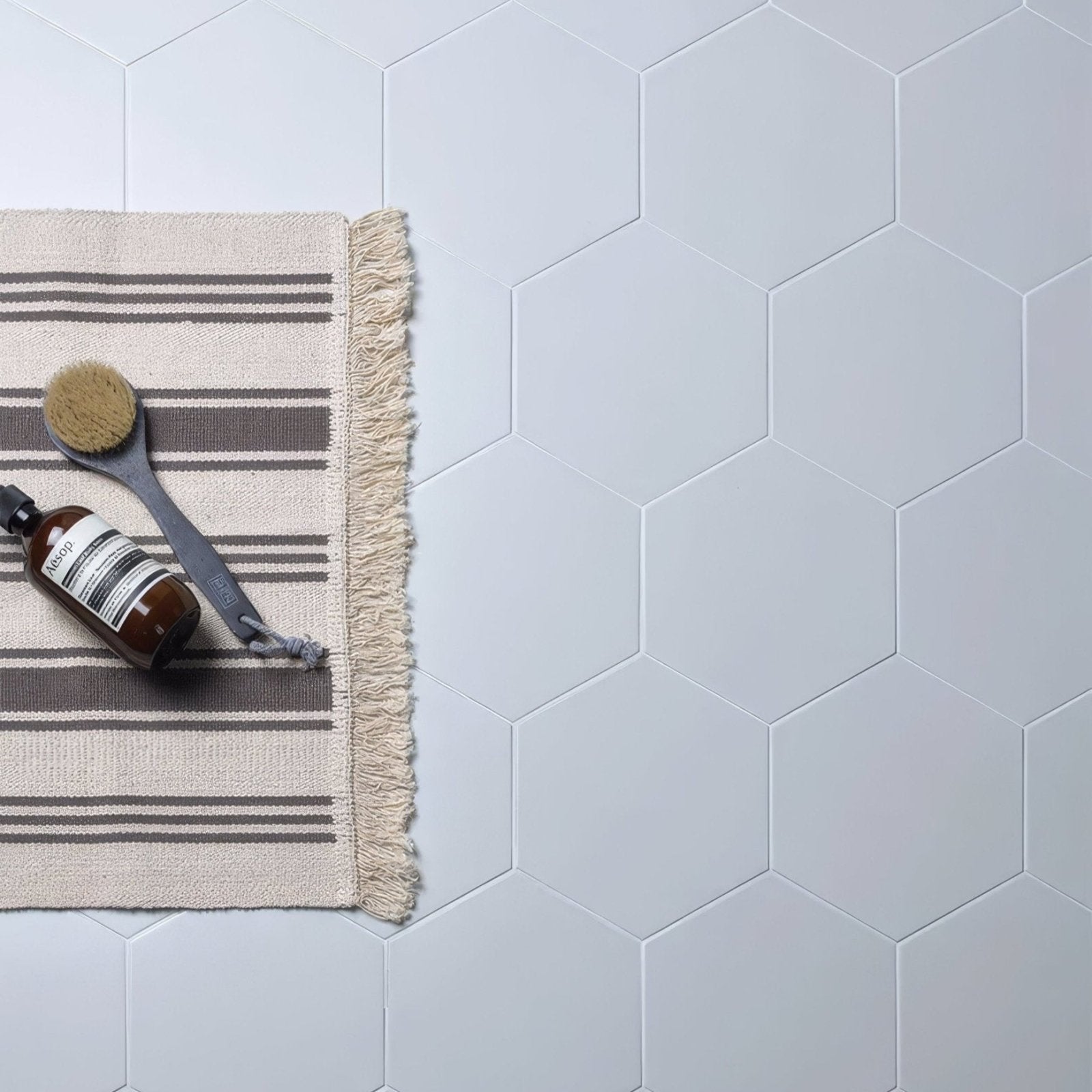 White hexagonal porcelain tiles form a clean modern bathroom floor in signature porcelain pearl white finish