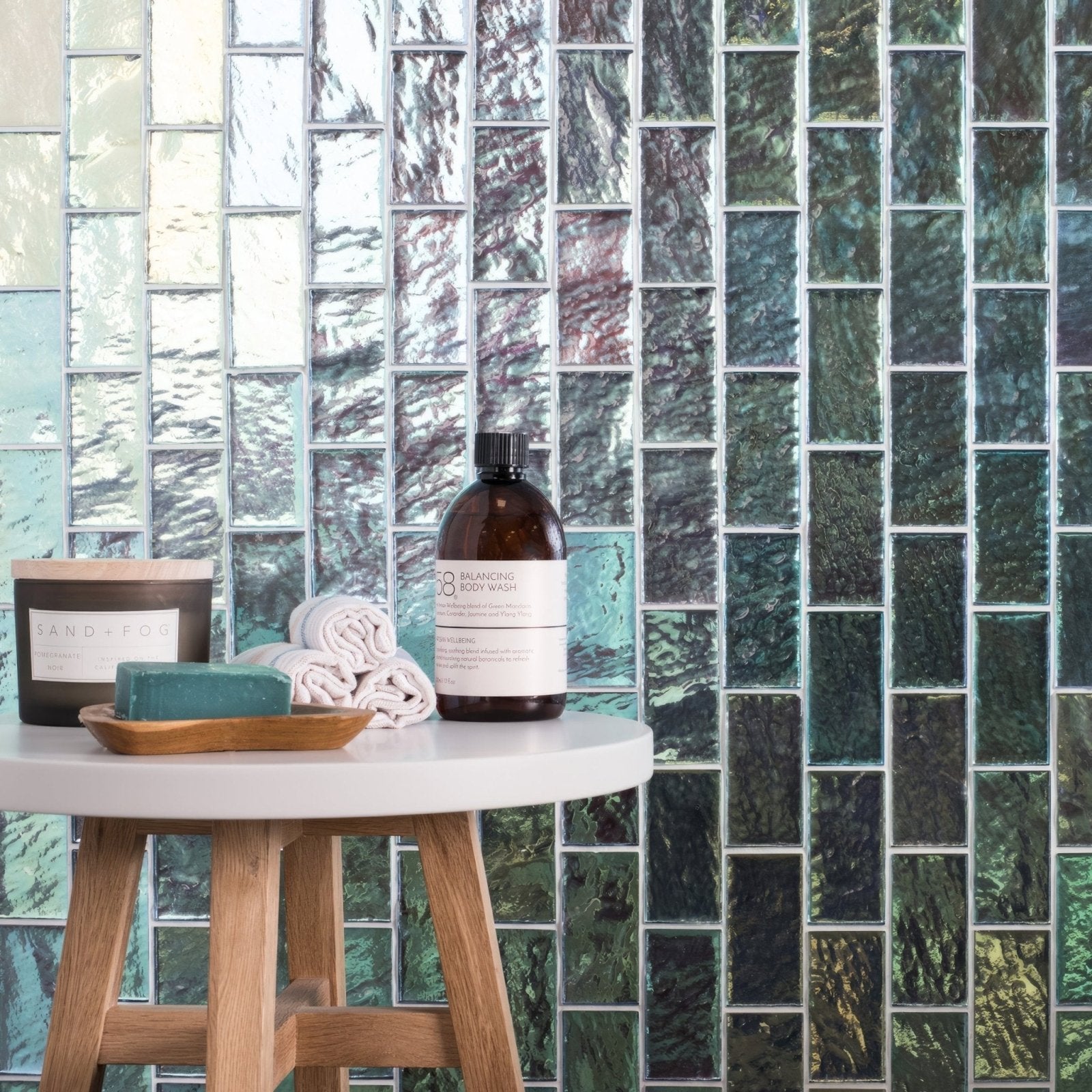 Silver Gloss Mosaic Radiance iridescent green and blue glass mosaic with an amber body wash bottle