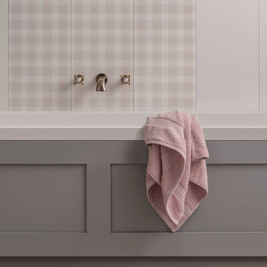 A soft pink plush towel with textured weave hangs over a gray bathtub simplicty matt 60x30cm