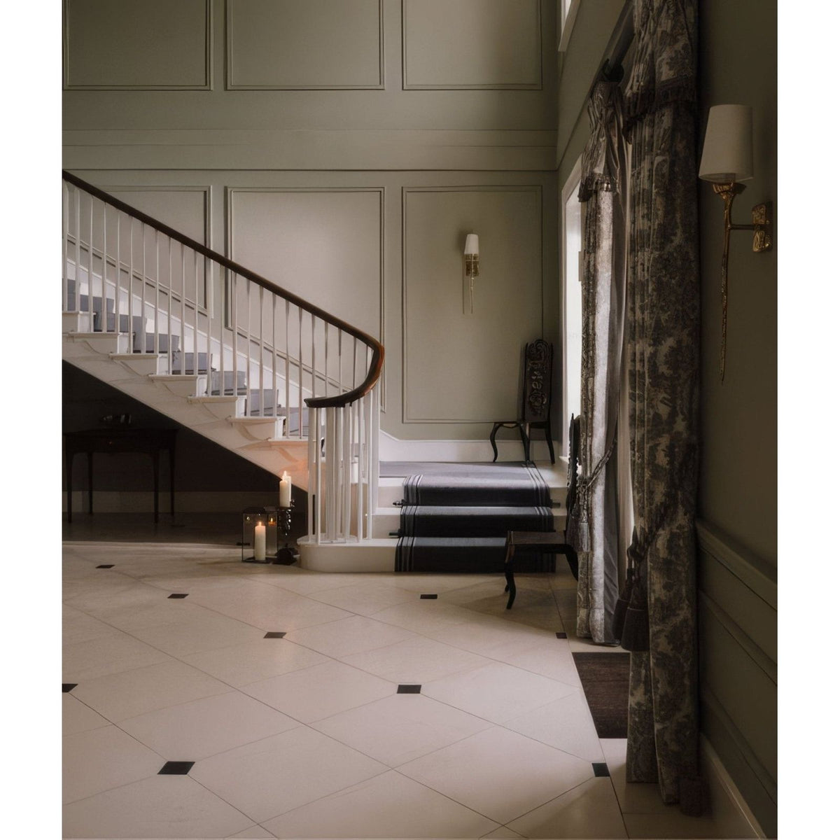 A navy blue runner with black stripes laid across white marble steps on a sloane limestone honed finish staircase