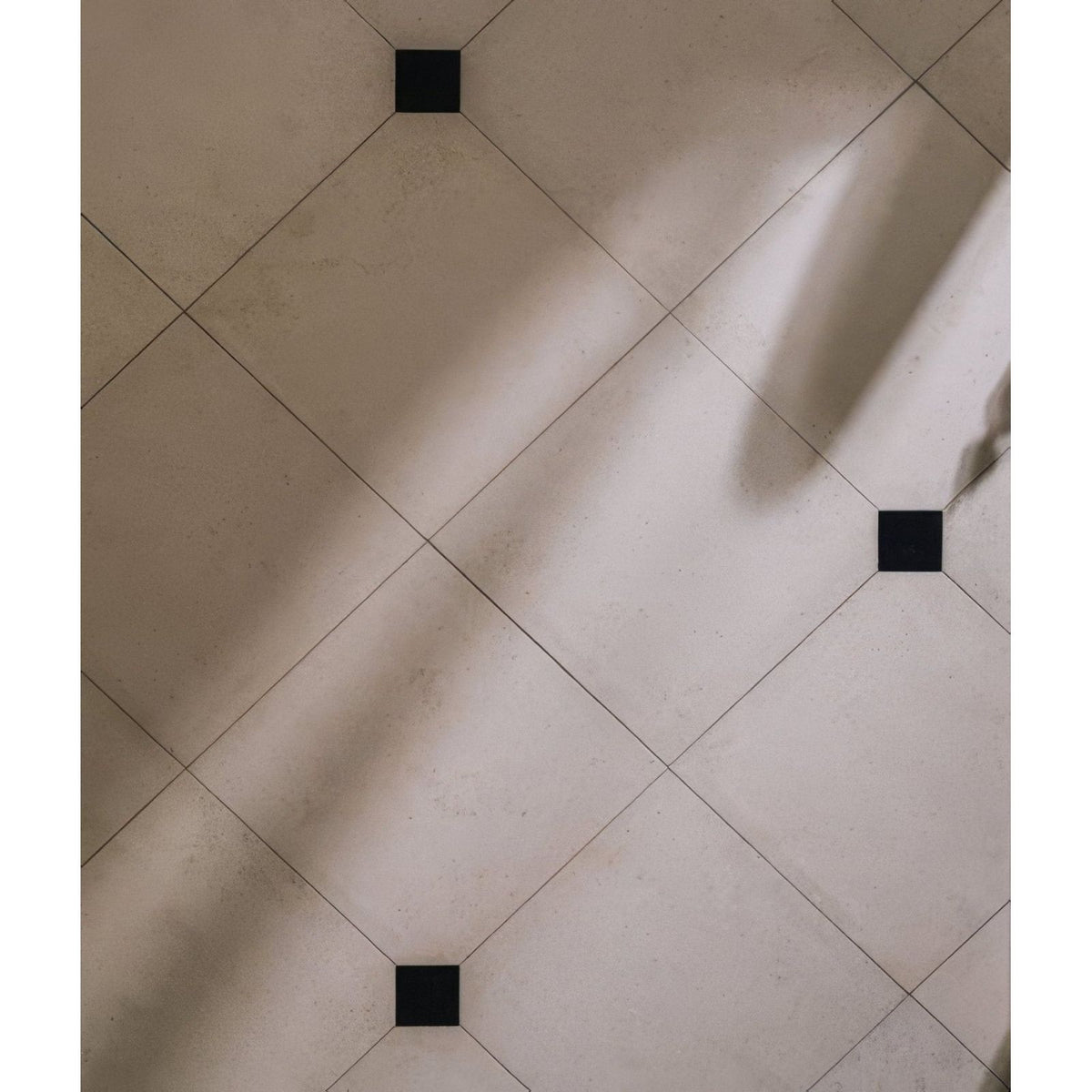 Beige sloane limestone honed finish tiled floor with black square accents for elegant indoor flooring