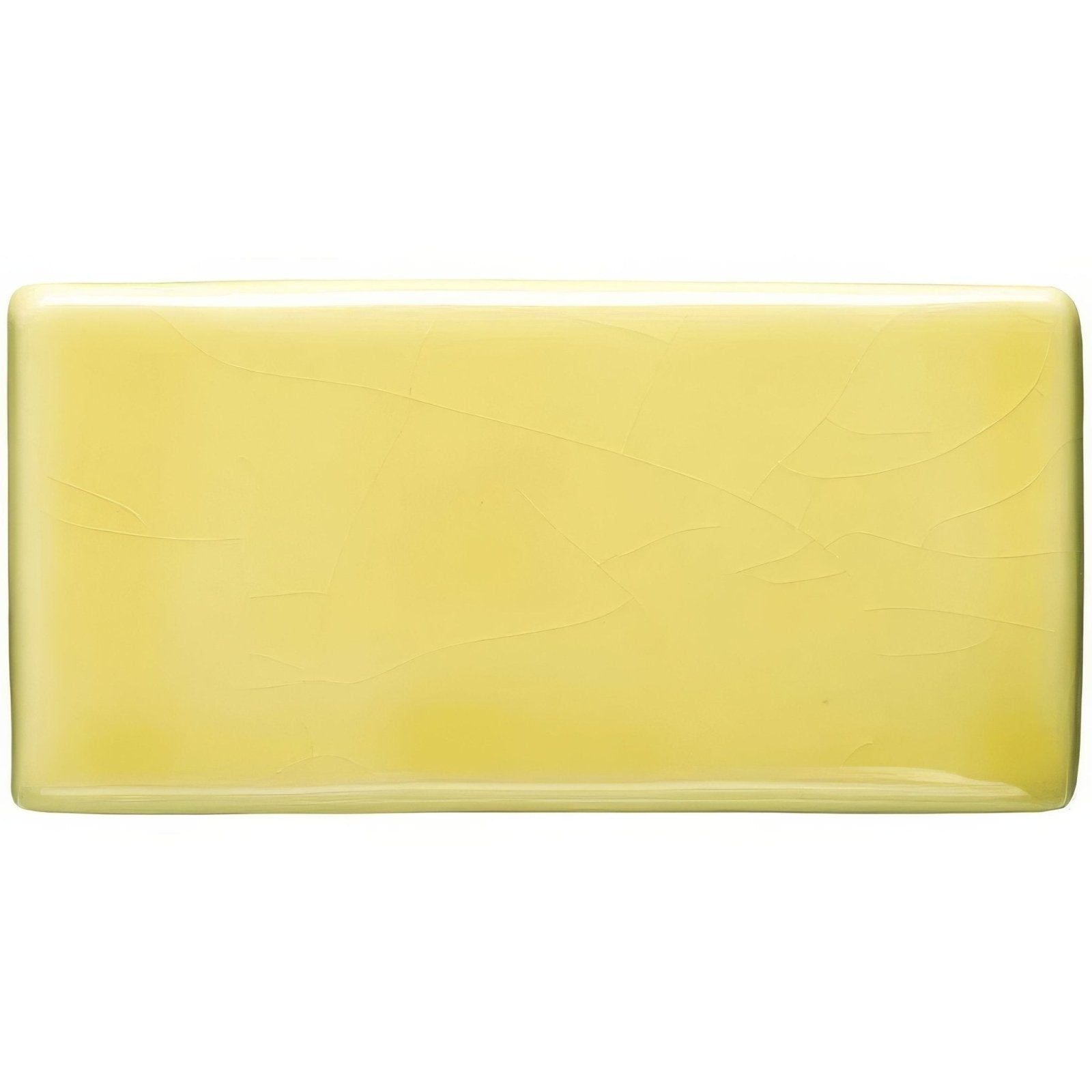 A rectangular pale yellow soft yellow half tile soap bar with a smooth slightly glossy surface and subtle texture