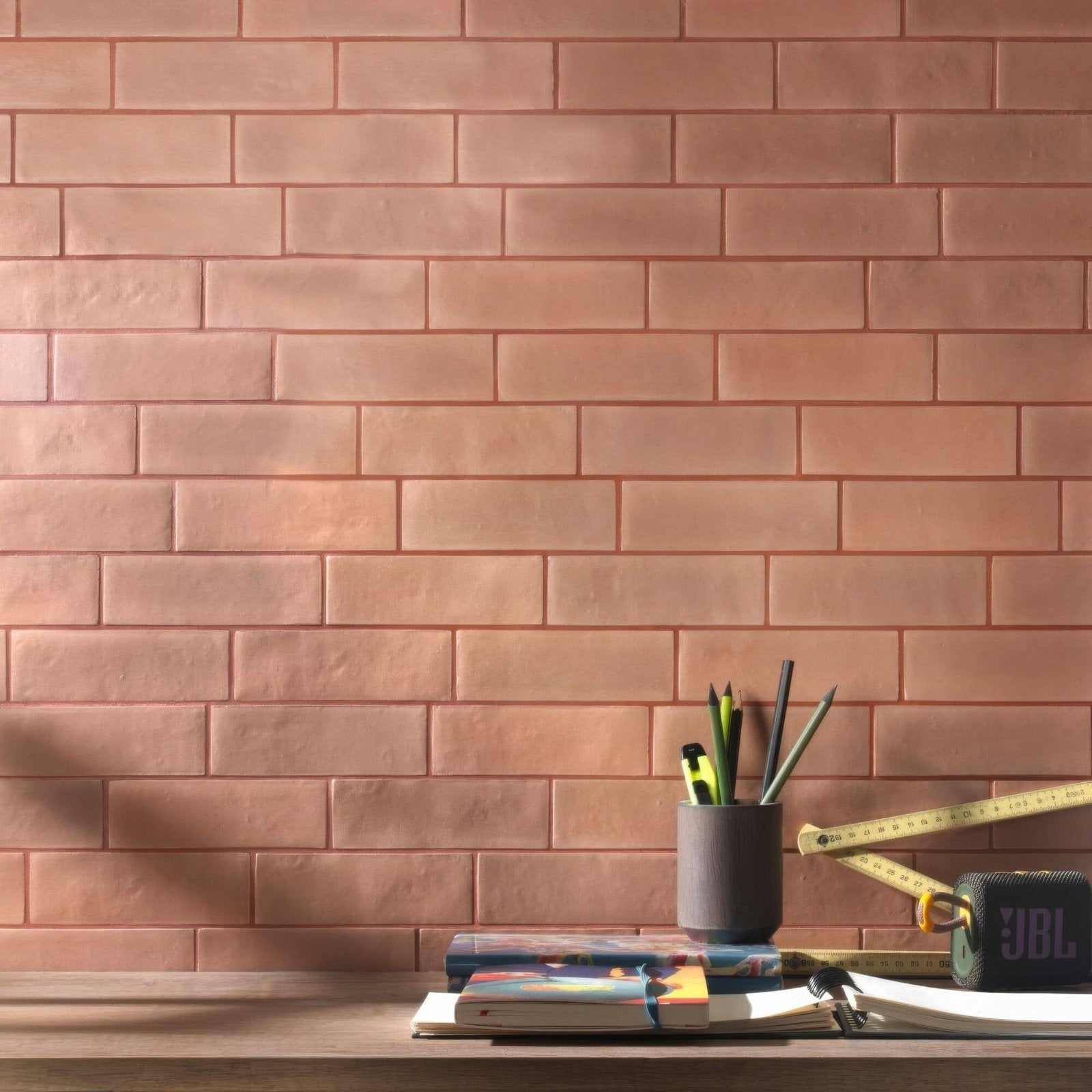 A matte black jbl portable speaker with a textured surface and visible branding for south cliff terra brick tile