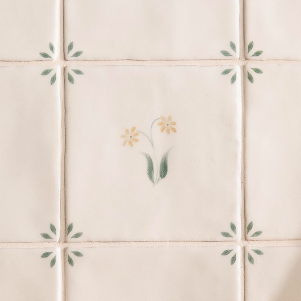 Cream-colored ceramic tile spring elsie 13 x 13cm with delicate hand-painted yellow flowers and green leaves