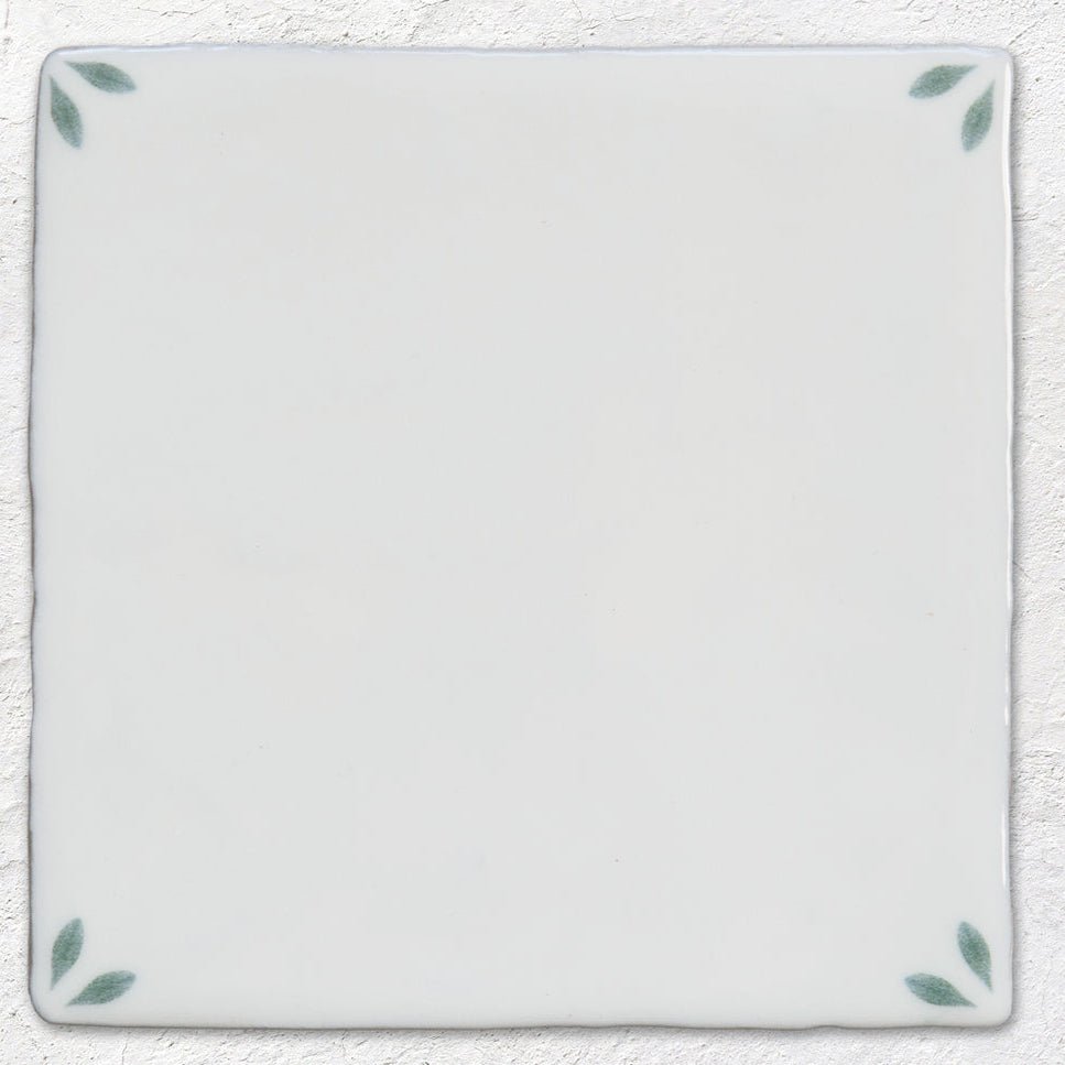 Spring May 13 x 13cm white ceramic tile with subtle sage green leaf motifs at each corner