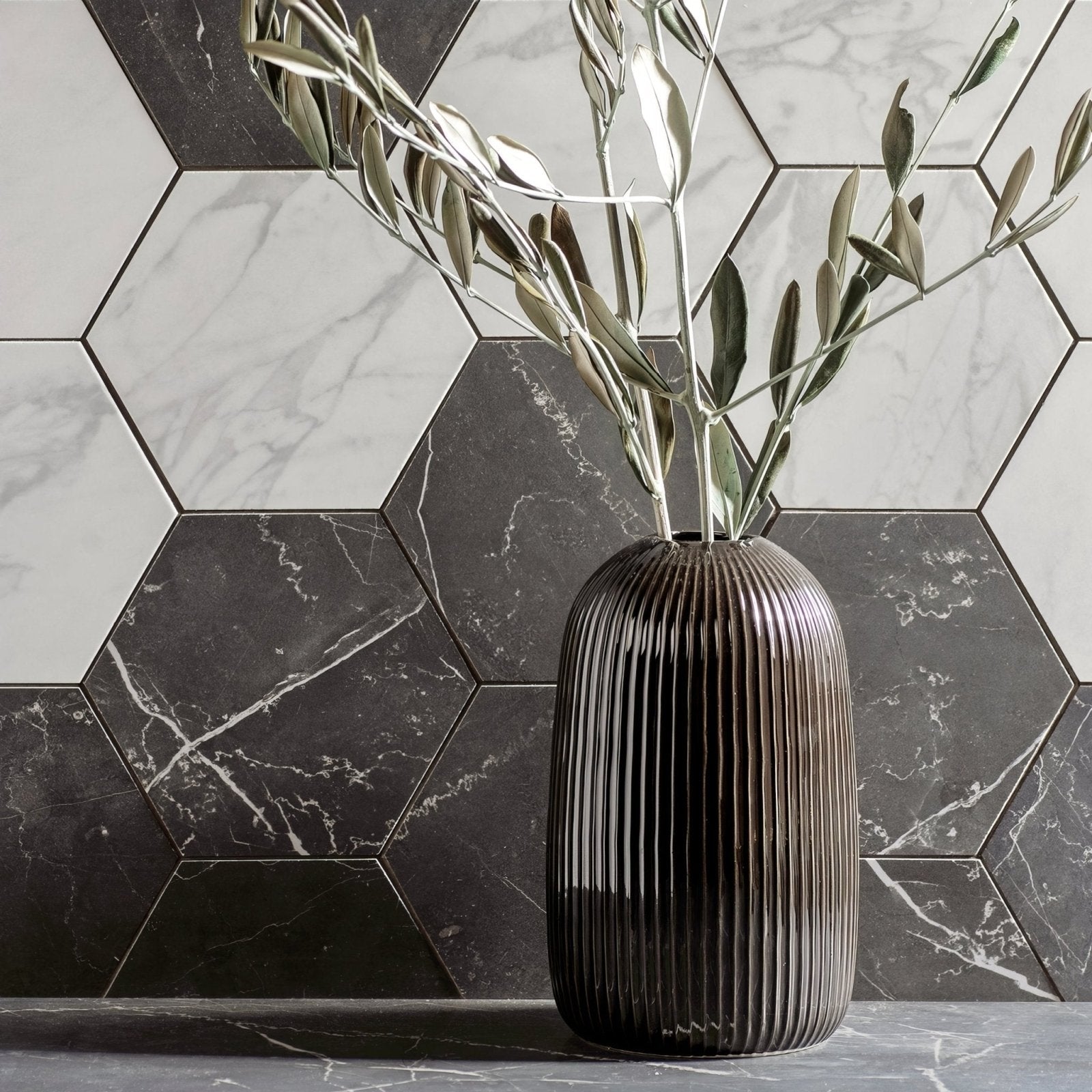 Statuarietto Honed Hexagon Mosaic white marble hexagonal mosaic with a dark brown vase of olive branches