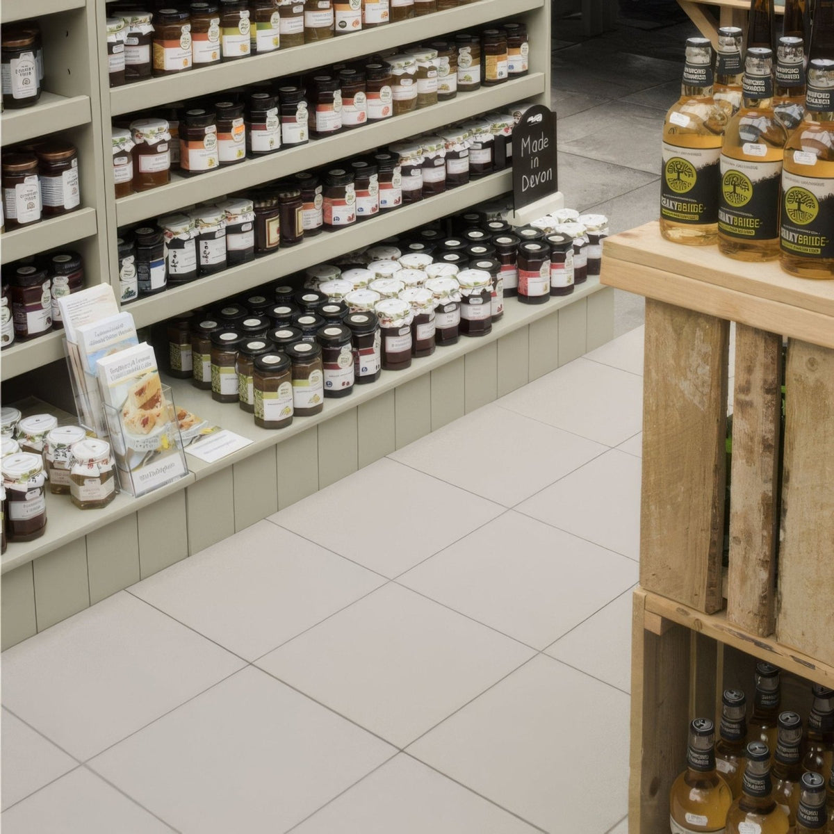 Rows of glass jars with colorful jams displayed on steel grey textured quarry tile 300x300x9mm store shelves