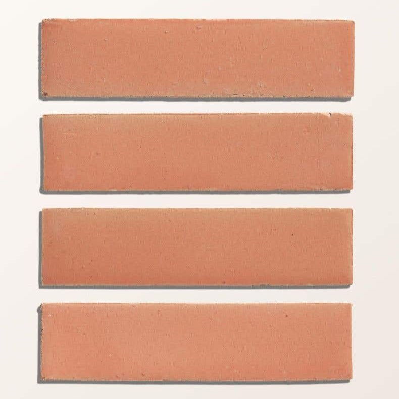 Four matte finish terracotta stone glaze ceramic blossom gloss brick tiles in uniform reddish brown color