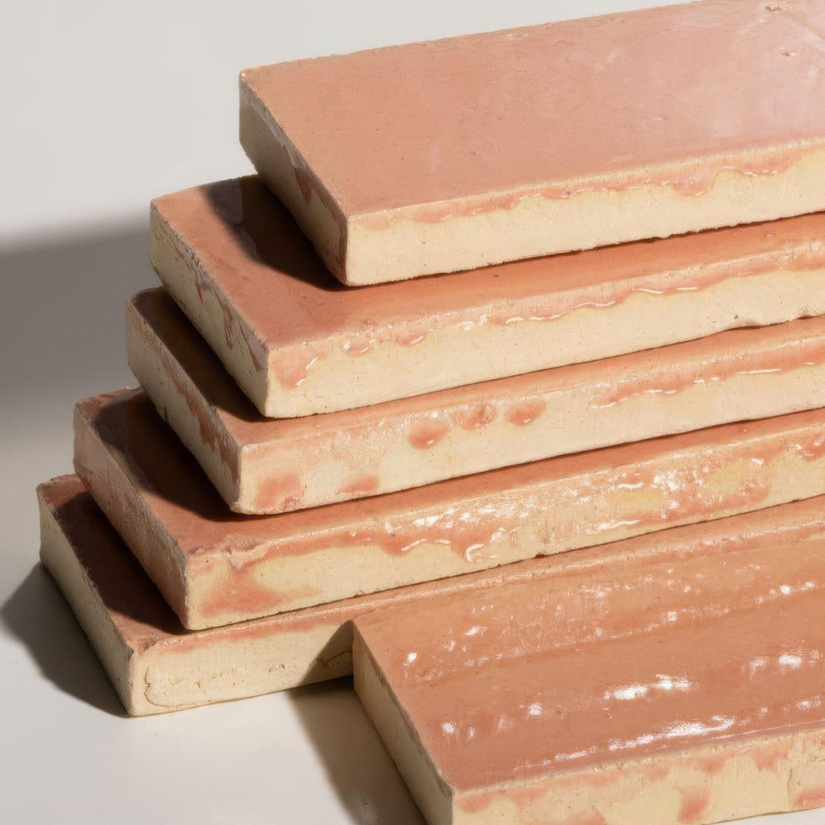 Stacked stone glaze ceramic blossom gloss brick tiles with warm pinkish brown glaze and cream clay edges
