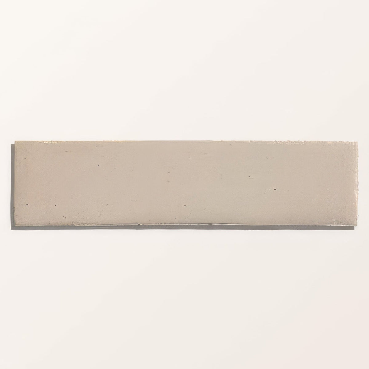 A rectangular beige stone glaze ceramic chalkstone gloss brick tile with matte finish and subtle imperfections