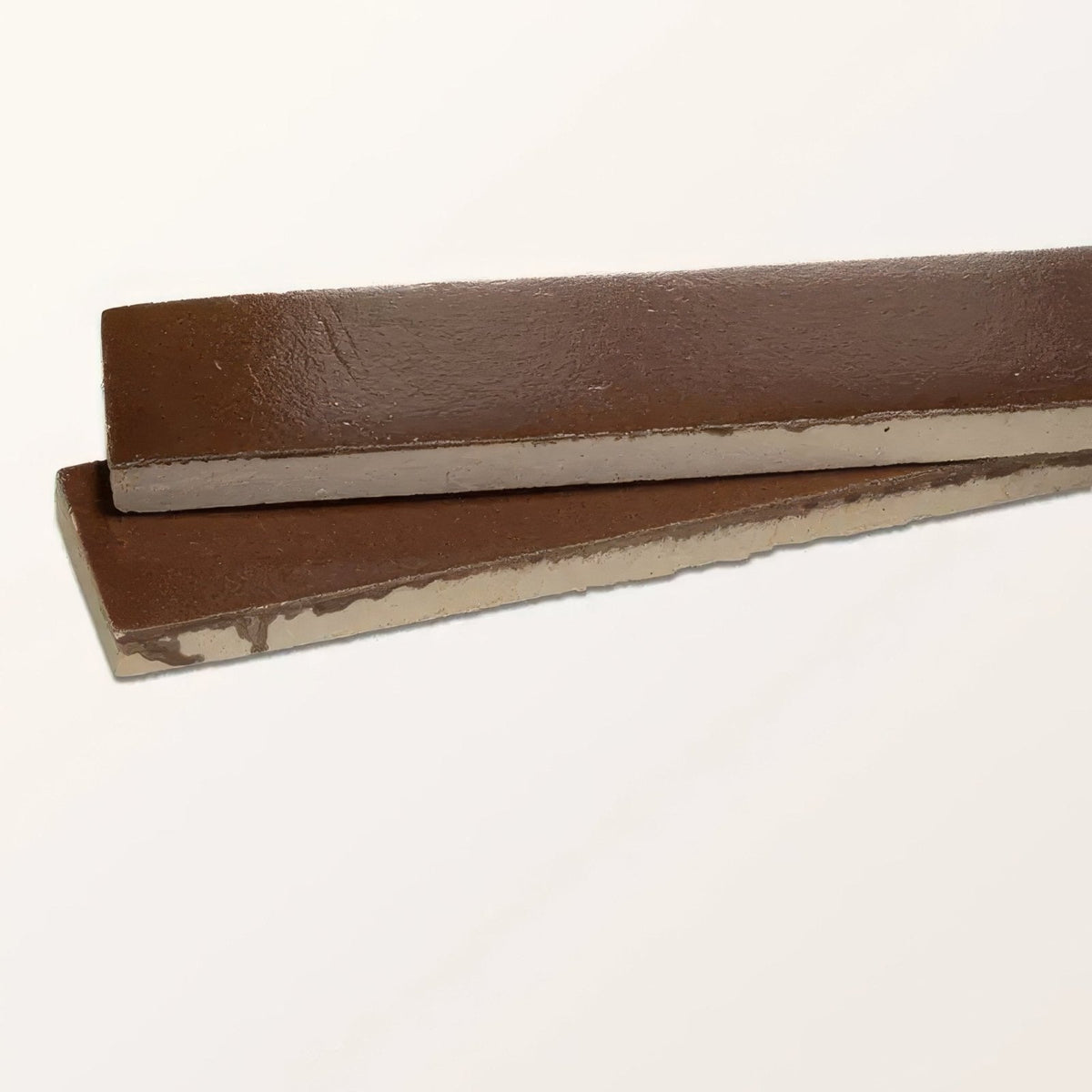 Brown leather strips with textured surface and visible stitching paired with stone glaze ceramic cola gloss brick
