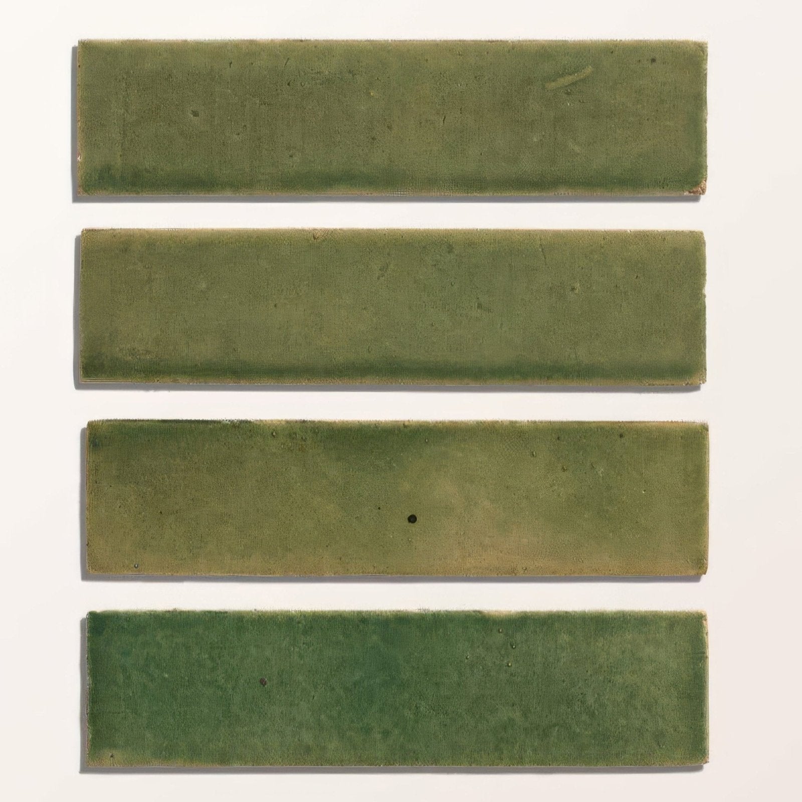 Four rectangular green matte ceramic tiles with subtle shade variations from stone glaze ceramic olive leaf gloss brick