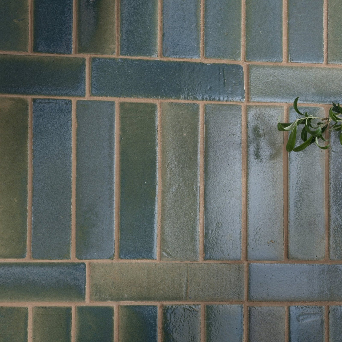 Rectangular stone glaze ceramic winter pond gloss brick tiles in muted blue and green with earth-toned grout in staggered pattern