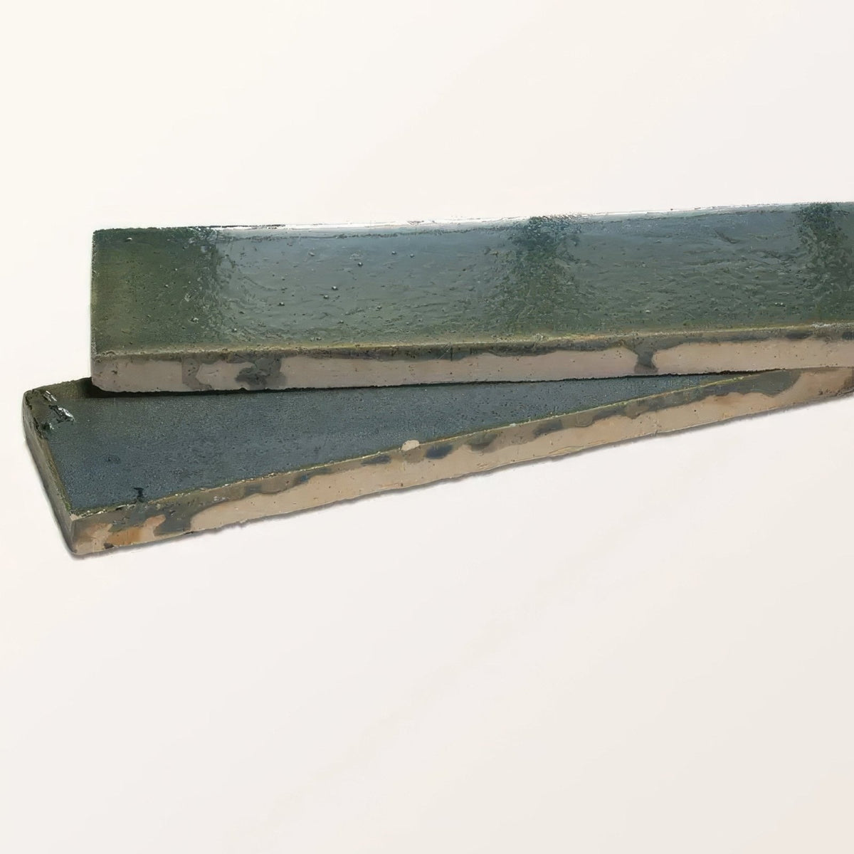 Two rectangular ceramic tiles with glossy muted green stone glaze and earthy undertones from winter pond gloss brick line