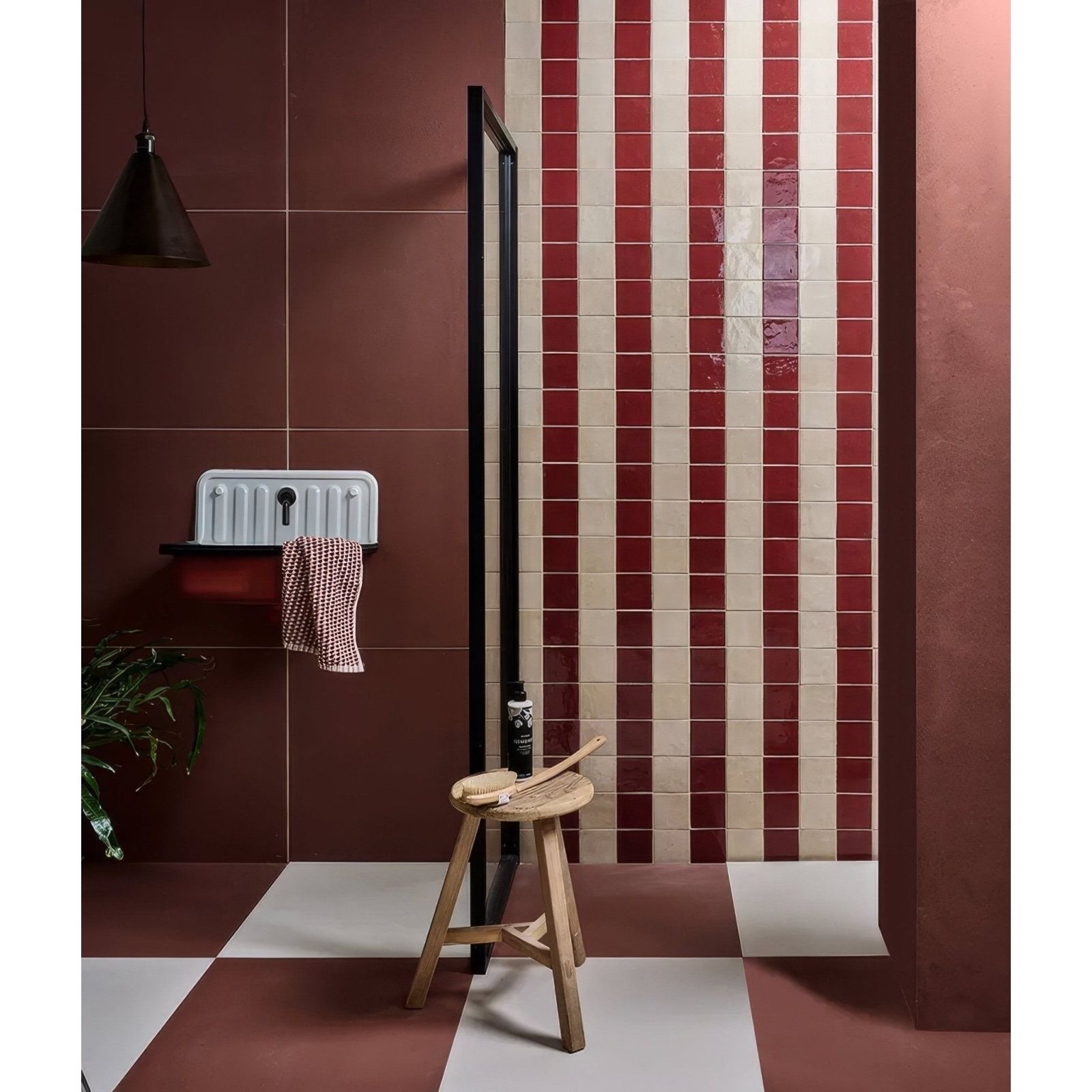 A stucco porcelain textured red ceramic sink with a white finish and black faucet mounted on a dark brown wall