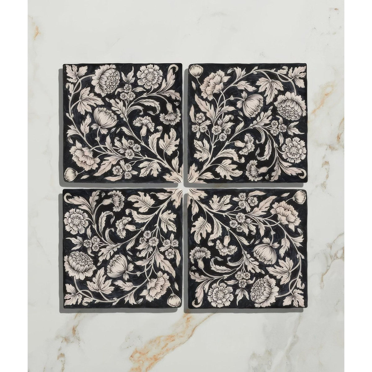 Studio assisi blue ceramic black square tiles with intricate white floral and botanical patterns in four-piece set