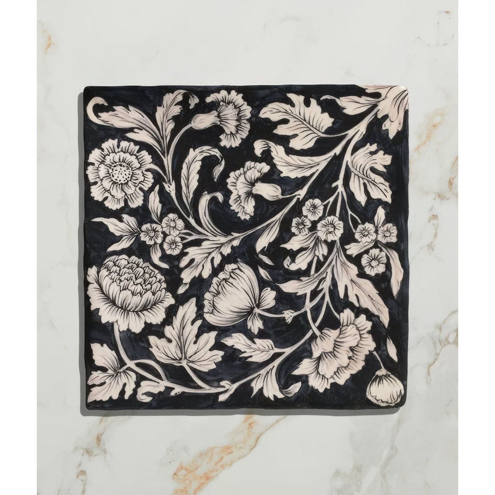 Black ceramic tile studio assisi blue featuring intricate white vintage hand-painted floral and leaf patterns