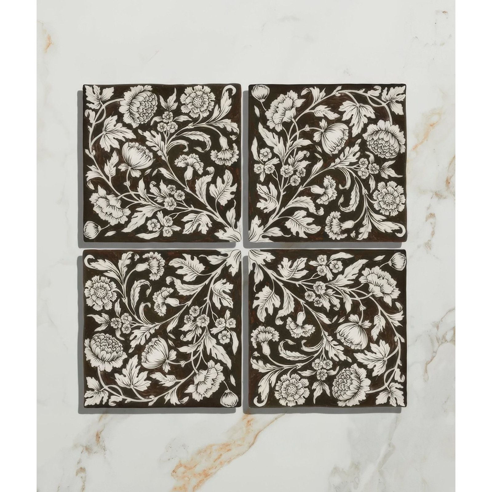 Set of four brown ceramic coasters with intricate white floral and botanical patterns from Studio Assisi brown ceramic