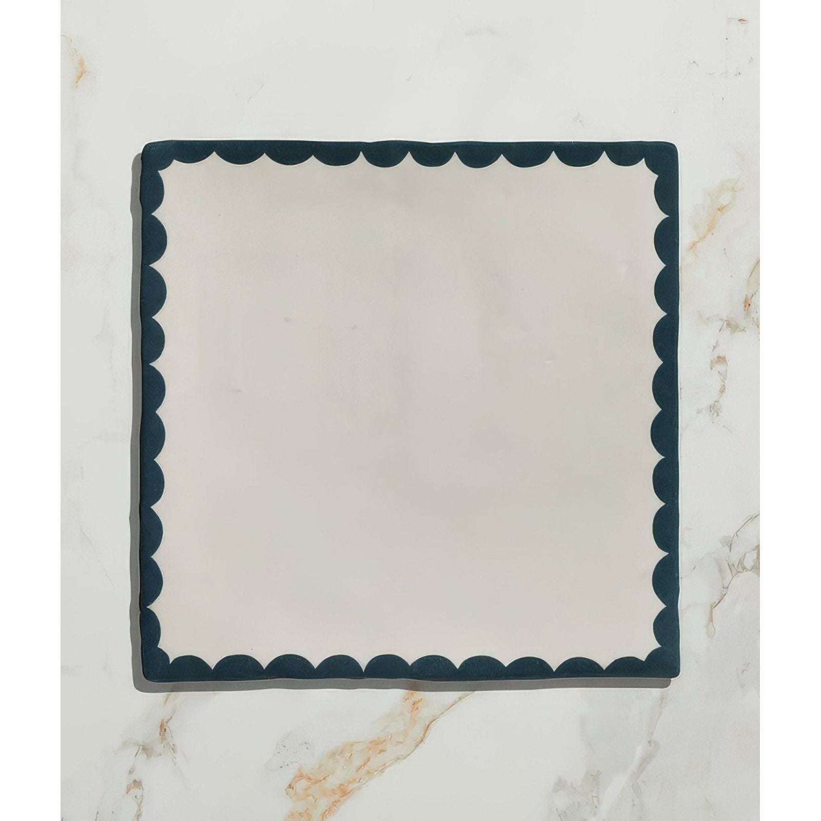 Cream-colored ceramic square plate with dark teal scalloped edge from Studio Bobbin Ceramic Blue collection