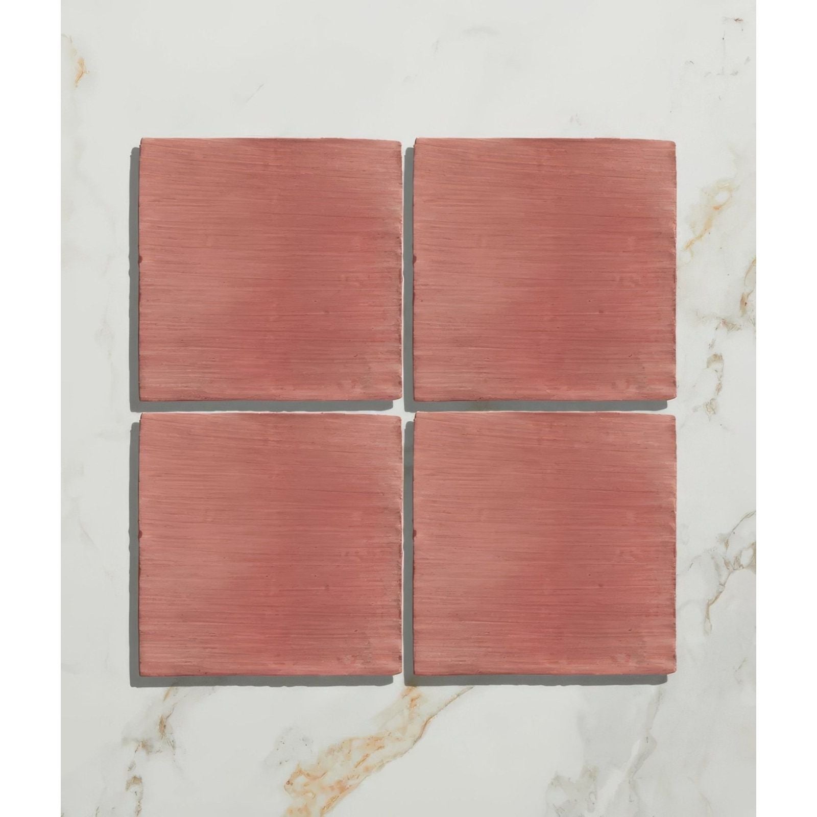 Four square matte terracotta tiles with earthy reddish-brown finish and subtle texture from studio jamboree coral field