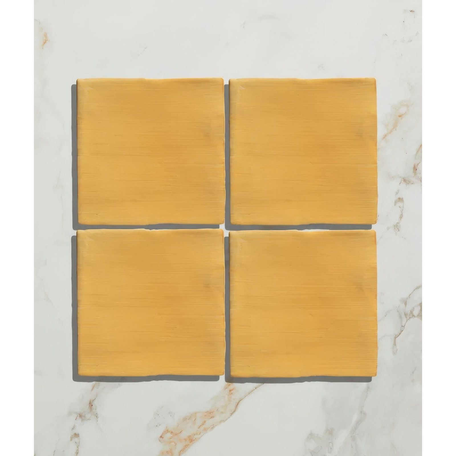 Four square mustard yellow handpainted ceramic tiles from studio jamboree summer field collection arranged in a grid