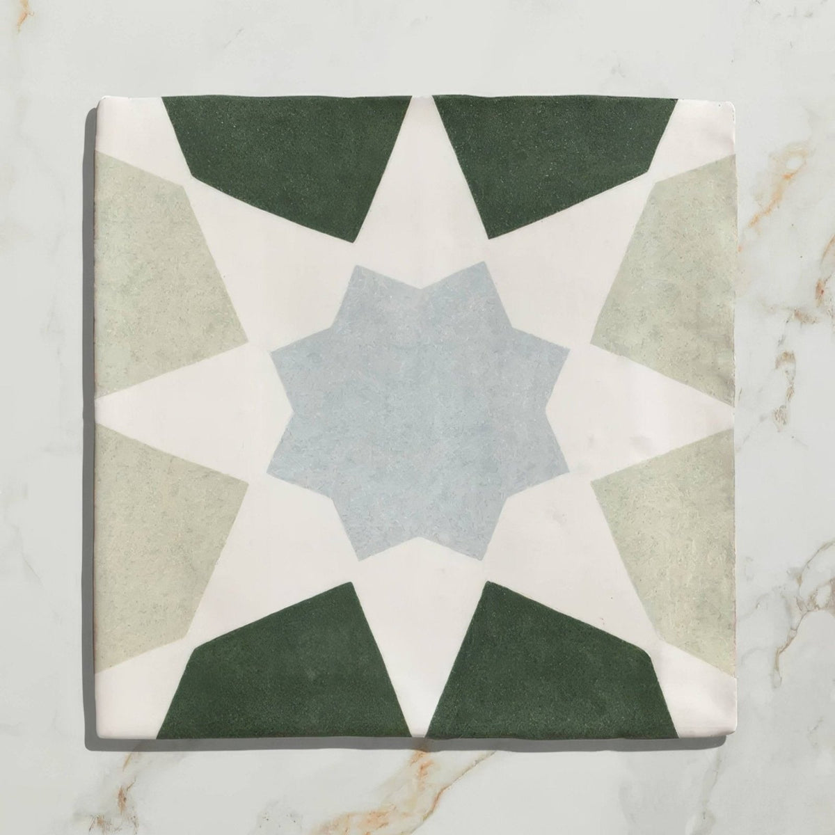 Square ceramic tile with geometric star pattern in muted green beige and light blue tones from Studio Souk Blue Star Ceramic