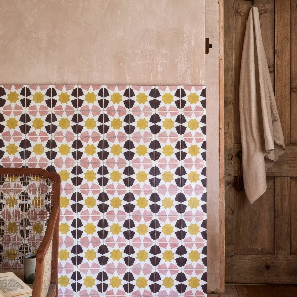 Studio souk yellow star ceramic geometric patterned tile wall with pink yellow and black starburst shapes on white