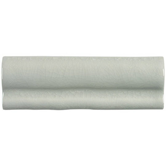 A sleek pale green ceramic torus moulding tern tile with subtle textured surface and gentle wave-like contours