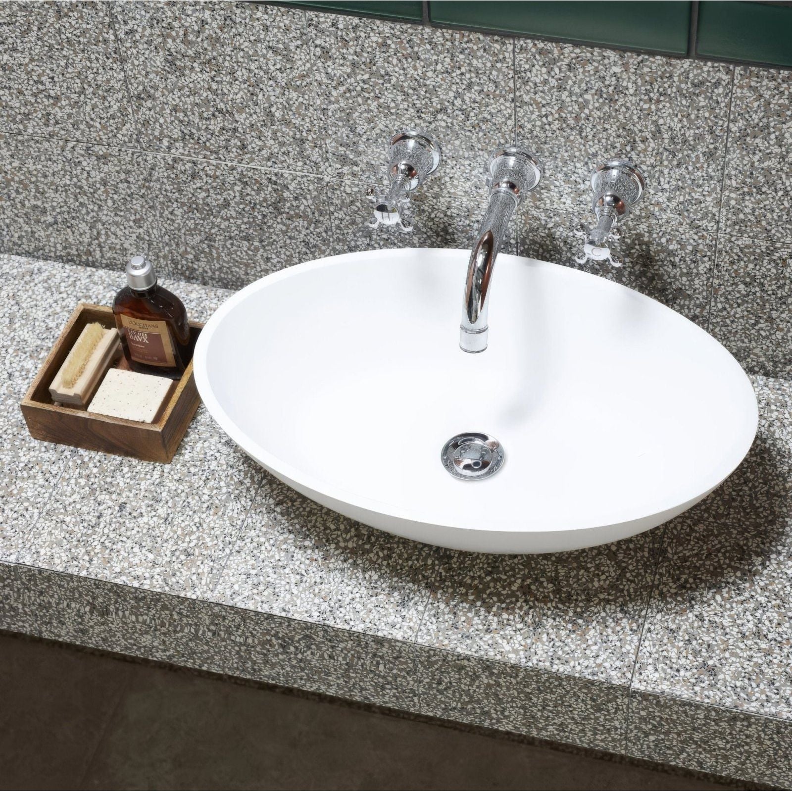 White oval terrazzo marini base sink with sleek chrome faucet and matching handles for bathroom use