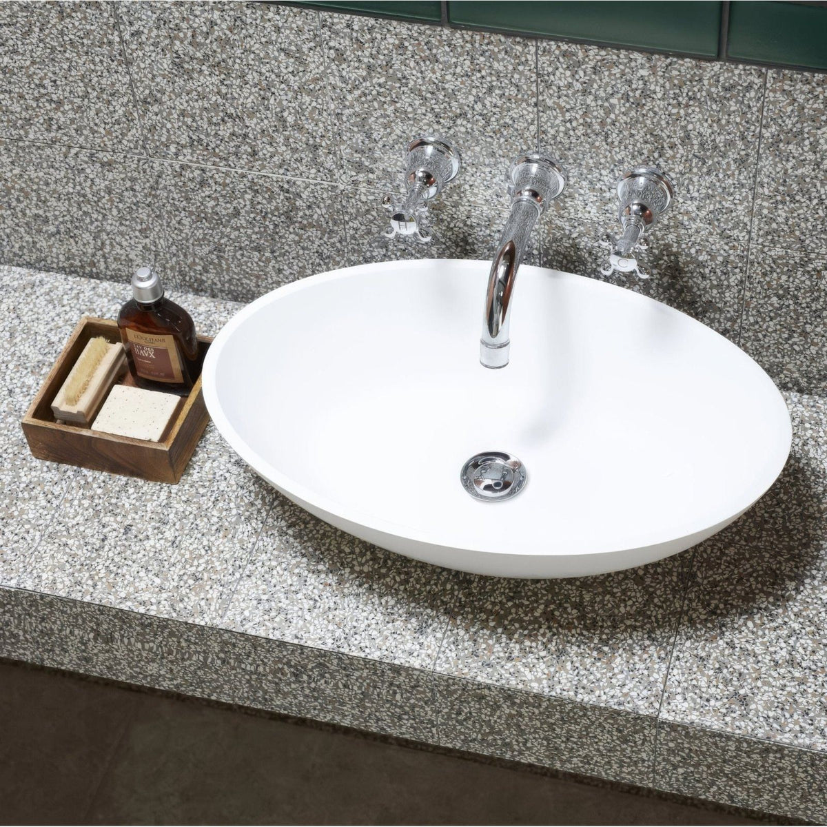 White oval terrazzo marini base sink with sleek chrome faucet and matching handles for bathroom use