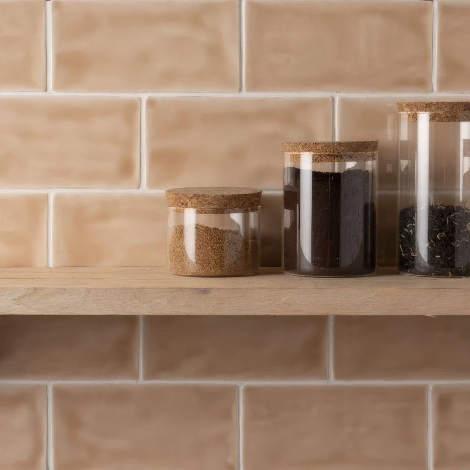 Three clear glass canisters with natural cork lids containing dried herbs for Thebes Brick Tile kitchen storage display