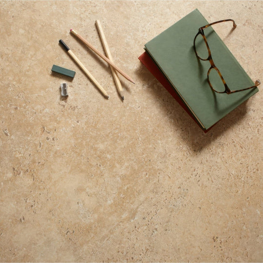 Stack of green and red books with tortoiseshell glasses on top beside beige tivoli 30 x 60cm tile