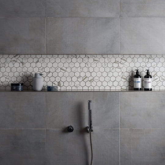 Torcello White Hexagon white hexagonal mosaic accent strip on a grey concrete wall
