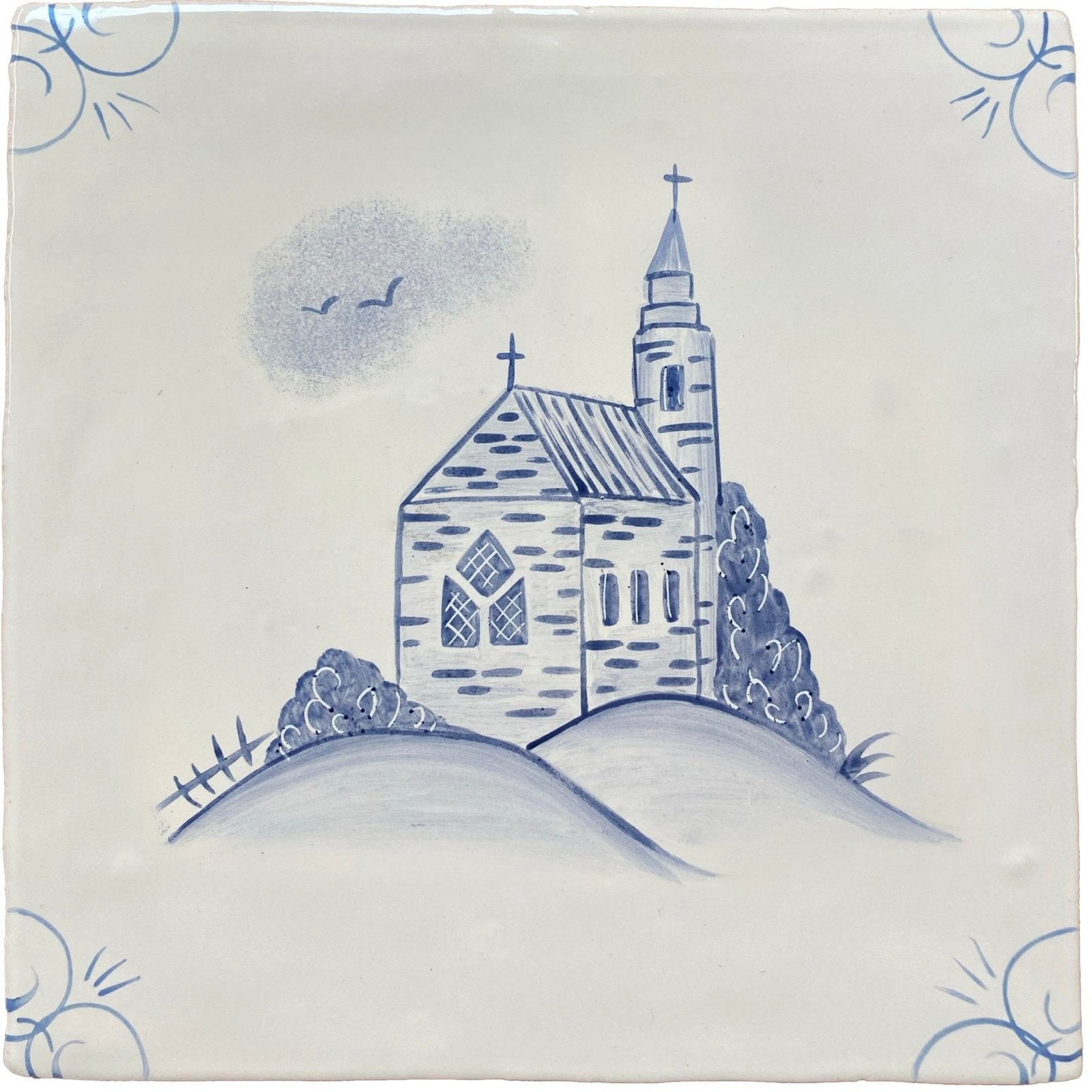 Blue and white ceramic tile hand-painted with a traditional English Delft church on a hill illustration