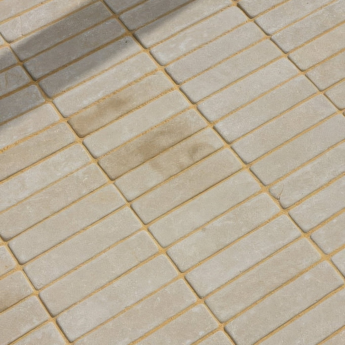 Beige rectangular sandstone tumbled klinkers with golden grout lines for decorative flooring and walls