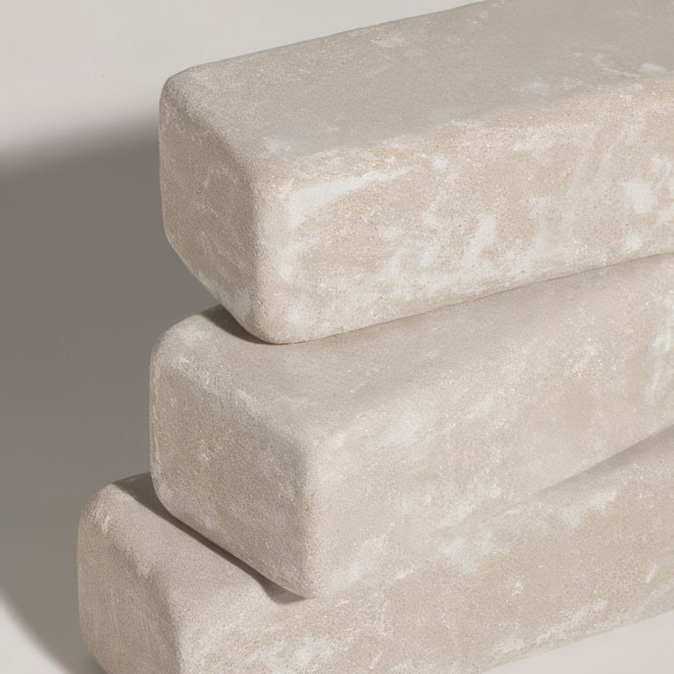 Stacked beige sandstone tumbled klinkers with a textured slightly weathered surface for outdoor paving
