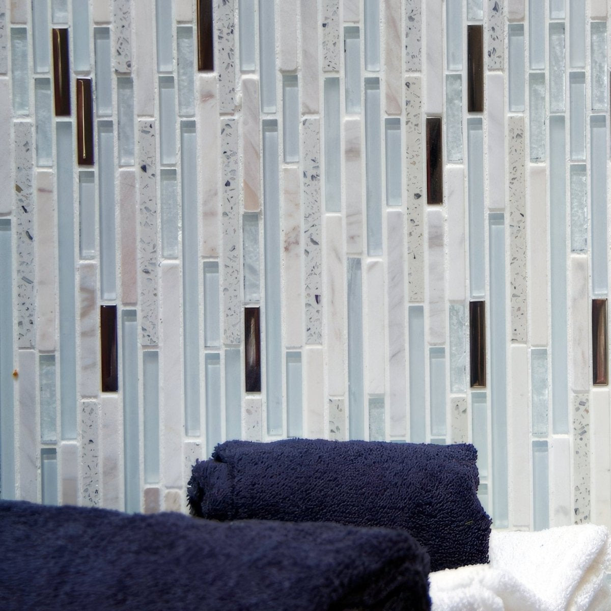 Trip Lluvia Blanco Mosaic light blue and white glass mosaic with a dark blue towel