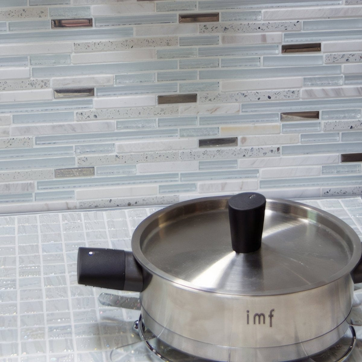 Trip Lluvia Blanco Mosaic light blue and white glass mosaic with a stainless steel saucepan