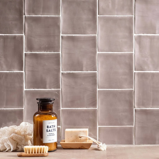 A rustic amber glass bath salts bottle with black cork stopper and minimalist label in truffle field tile style