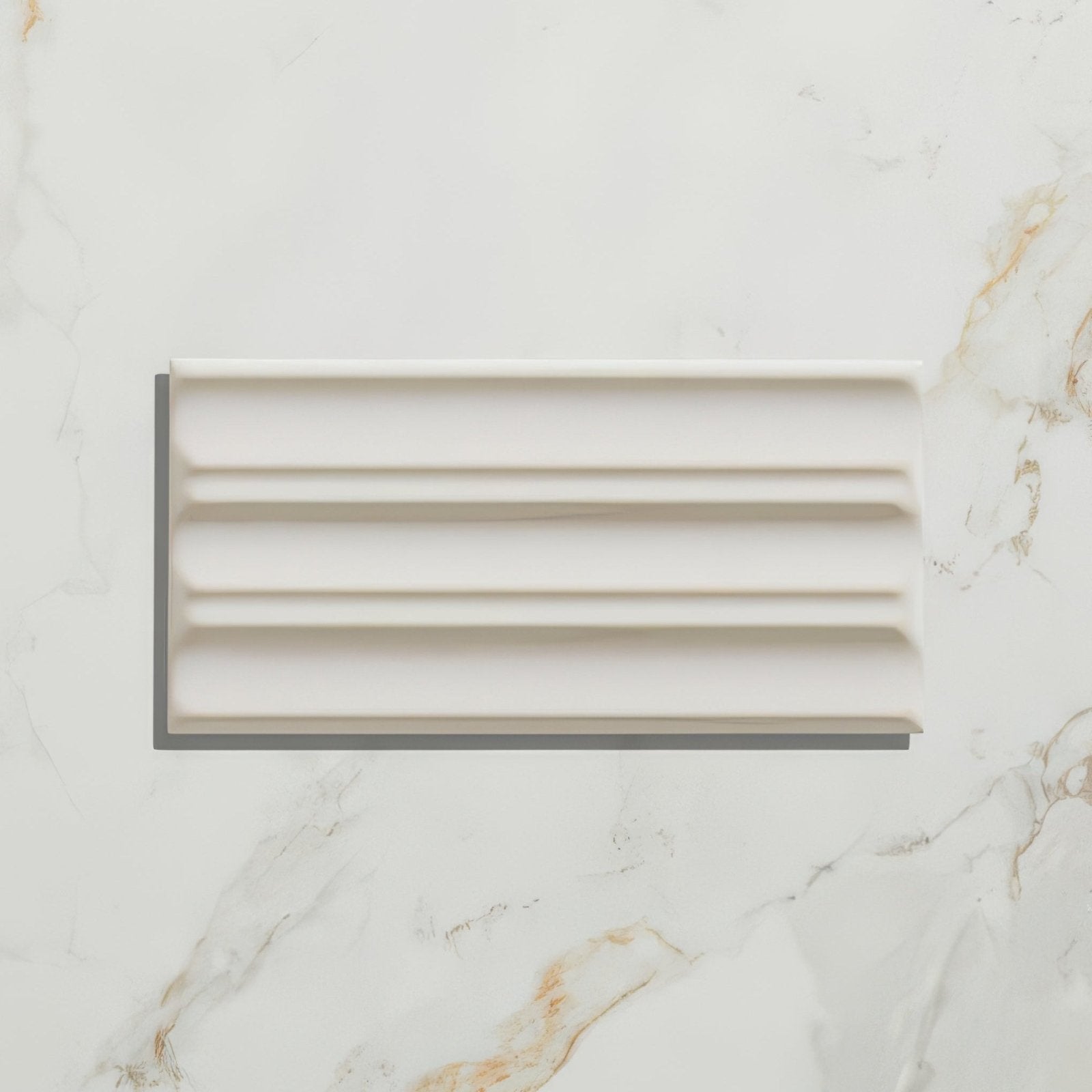Cream-colored rectangular ceramic tile with a classic ribbed design from tunstall ceramic fluted brick deep white collection