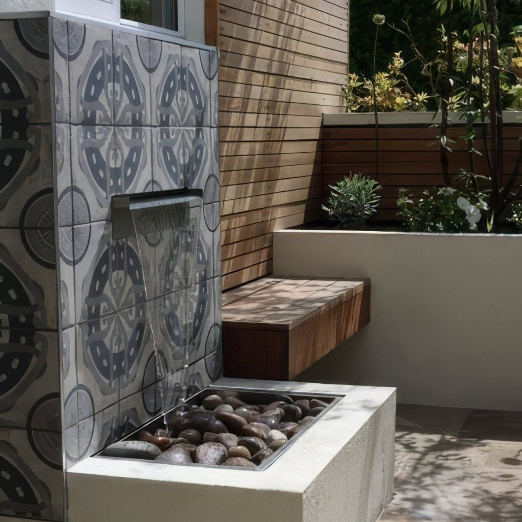 A modern outdoor water feature with a sleek rectangular basin and cascading waterfall on gray urban aryz patterned porcelain tile