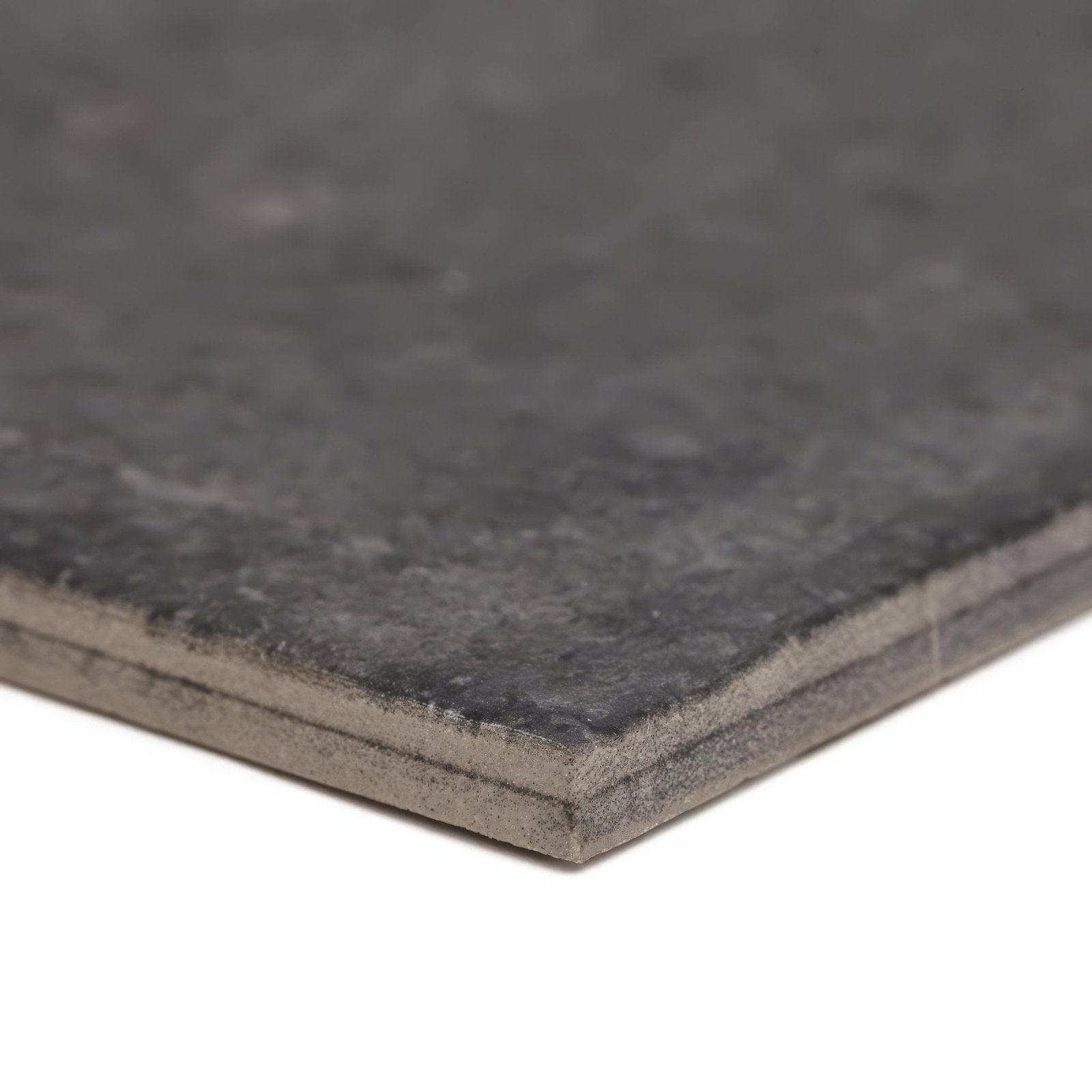 Urban charcoal plain porcelain tile in dark gray with textured surface speckled finish and visible layered edges