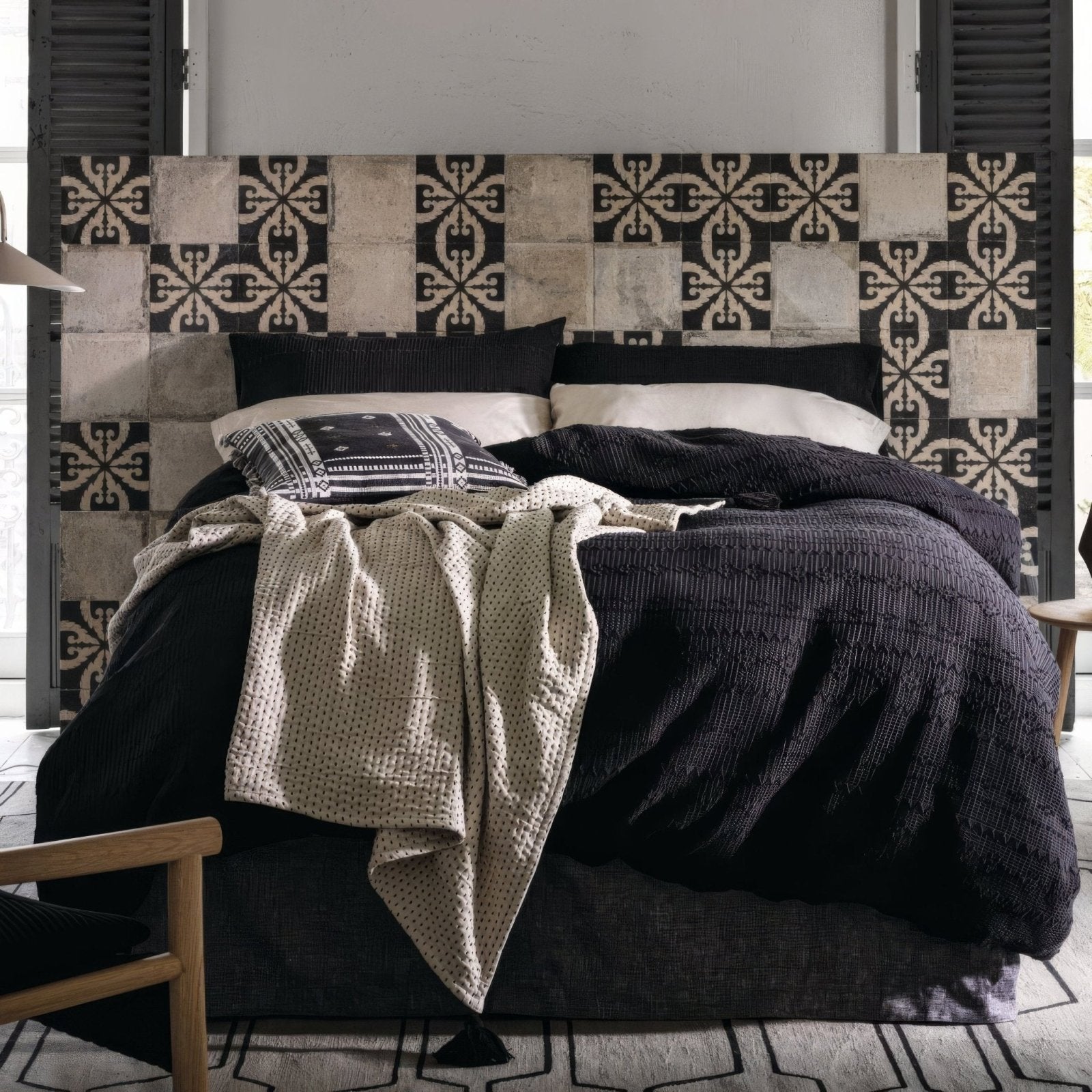 Black and white patterned porcelain tile headboard with a textured rustic finish from Urban Velasco collection