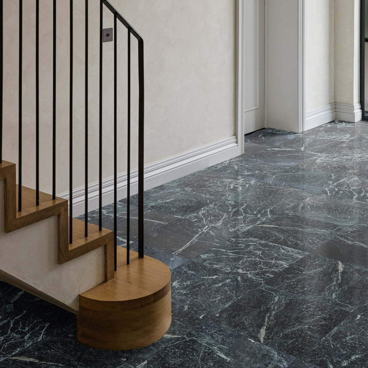 Dark gray marble flooring with swirling white veining in versailles marble vert honed finish