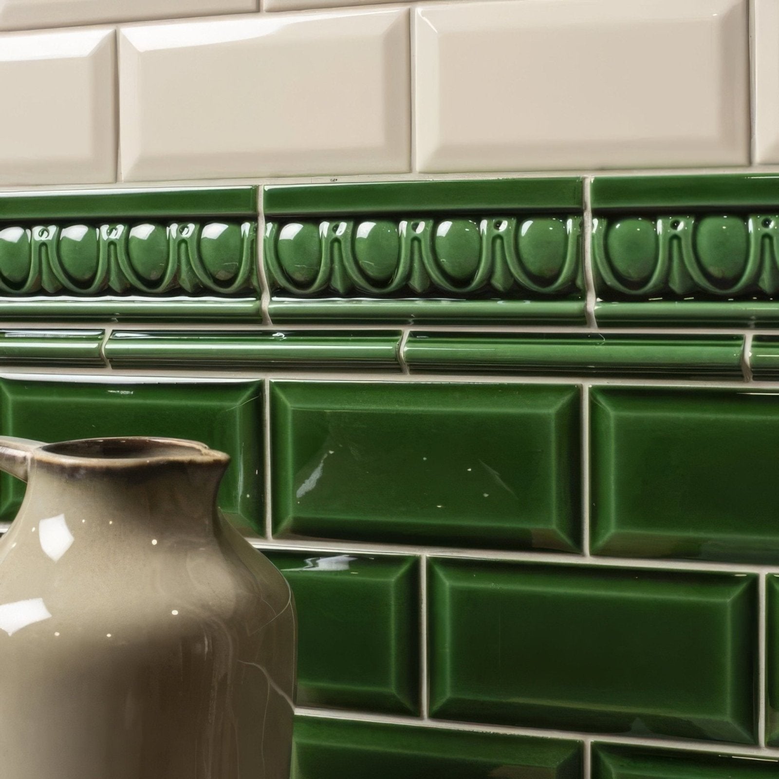 Deep green ceramic subway tiles with a glossy finish and embossed decorative border for victorian style walls